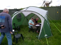 Rear view of Bill M0TDW with John G1OQV operating & Neil M6CUE logging in the main op shelter.